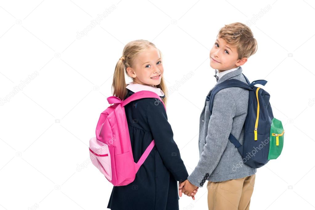 Bambini con zaini colorati davanti alla scuola